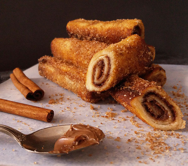 Nutella French Toast Rolls are easy and delicious stuffed French toast rolls to serve for breakfast. Once done, rolled in cinnamon sugar, and served hot, they are the best roll recipe!