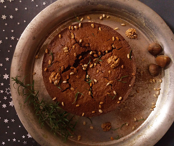 Castagnaccio : Italian rustic festive cake with chestnut flour, walnuts, rosemary and pine nuts.