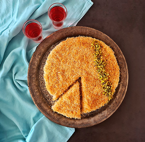 Knafeh is traditional Levant dessert made with kadayif, attar, and vanilla filling. Knafeh is traditional Levant dessert made with kadayif, attar, and vanilla filling.
